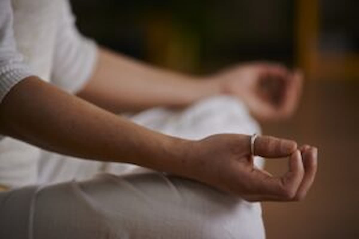 Illustration of a woman meditating peacefully beside a sunlit window with candles, Arlington Meditation